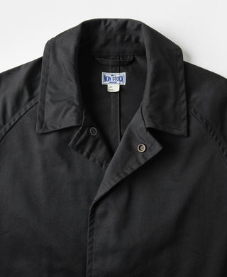 Black all-weather trench coat with notched lapel and snap-button collar tab