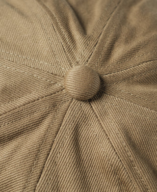 Khaki biker cap top button with gathered seam lines.