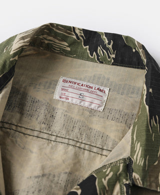 Camo jacket interior with size/identification label and stitched lining detail.