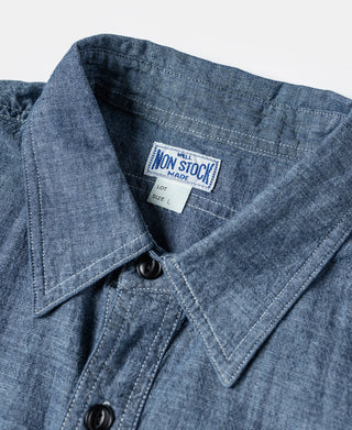 Blue chambray shirt collar with black button placket and inside neck label.