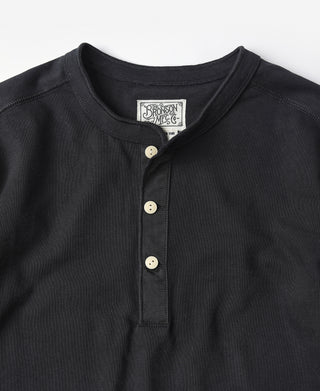 Black henley neckline close-up with ribbed collar and three cream buttons.