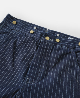 Indigo pinstripe pants close-up showing waistband buttons and pleated front