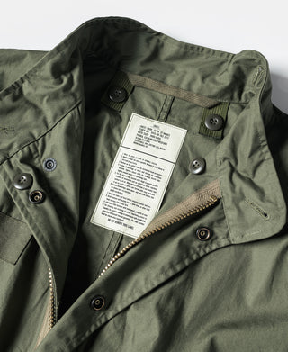 Olive green parka with buttoned flap pockets and visible care label