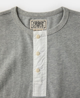 Gray henley T-shirt close-up: white button placket with three buttons and neck label