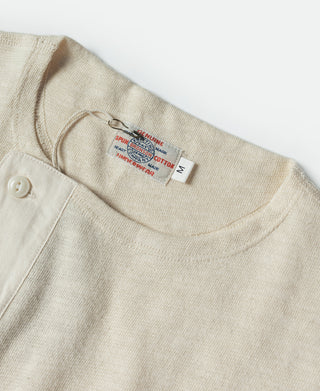 Beige crew neck henley with white buttons and neck label