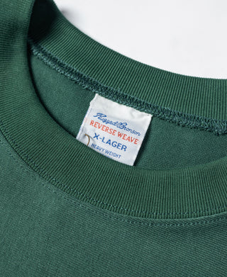 Close-up of green T-shirt ribbed crew neck with woven label at collar.