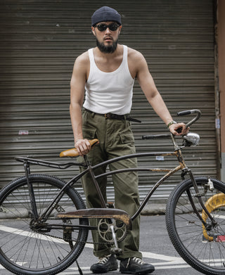 White sleeveless cotton tank top on a man standing with bike