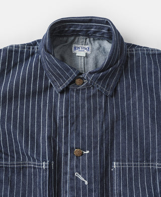 Indigo pinstripe work coat front close-up with snap collar and brass-tone buttons