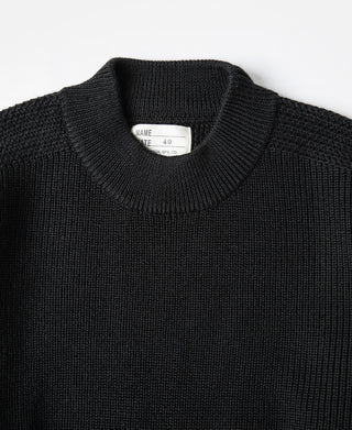 Black wool crewneck sweater close-up, ribbed collar with inner neck label