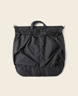 Black nylon helmet bag with front flap detailing and top handle