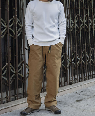 Khaki cotton canvas climbing pants worn with a light top and cuffed ankle hems