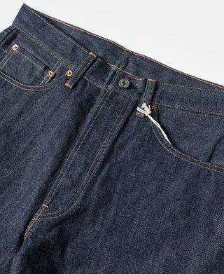 Dark blue denim jeans close-up of waistband, metal button, and fly with drawstring tie