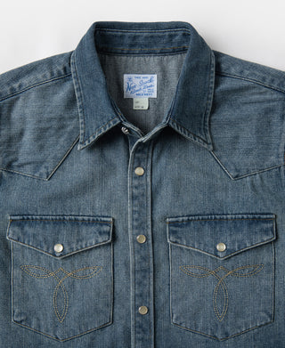 Blue slub denim western shirt with point collar, snap placket, and two chest pockets.