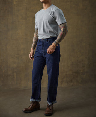 Gray cotton tubular T-shirt worn with dark blue jeans on a male model.