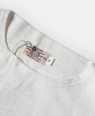White short-sleeve henley T-shirt with three-button placket, size label visible