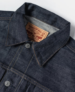 Indigo denim jacket collar with interior brand tag and button closure