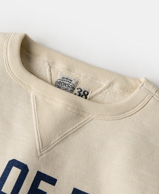 Cream crew neckline with V-inset detail and “38” neck label
