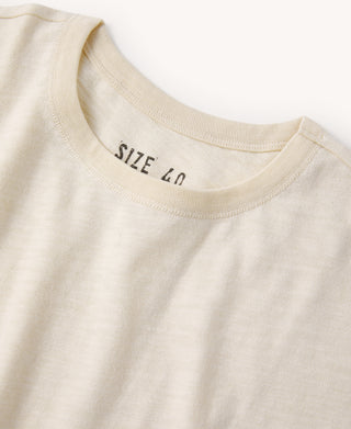 Close-up of light apricot crew-neck slub cotton T-shirt collar with SIZE LO label