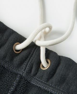 Black sweatpants with white drawstring and metal eyelets at waistband