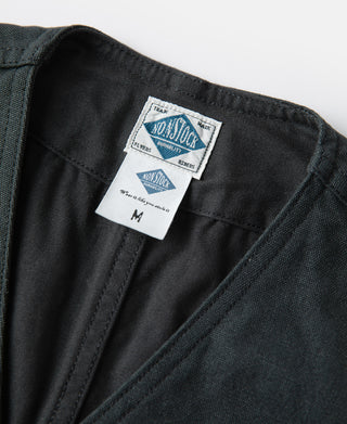 Dark green canvas vest interior with woven size label and V-neck facing