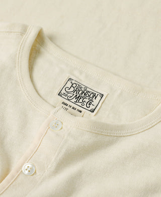 Cream slub cotton henley T-shirt with crew neckline and two-button front placket, chest tag