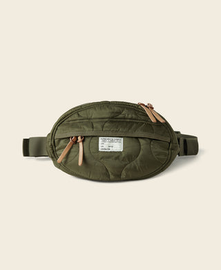 Olive waist bag with front label, zipper pocket, and adjustable side strap