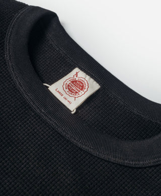Black waffle-knit crewneck collar with small interior brand label