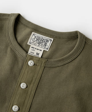 Olive henley t-shirt neckline with white buttons and The Bronson Mfg label