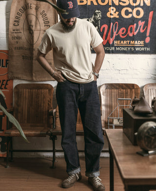 Apricot athletic T-shirt with crew neck worn with dark jeans and sneakers