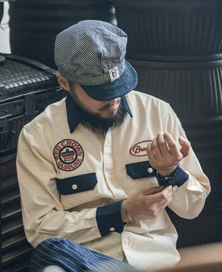 Railroad engineer cap on model, navy-and-white stripes with front emblem patch