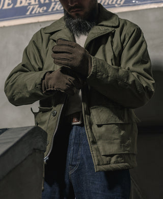 Olive flight jacket front with zipper and snap placket detail worn by model.
