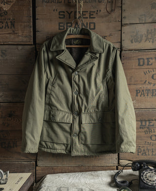 Olive flight jacket front with stand collar, button placket, and chest pockets