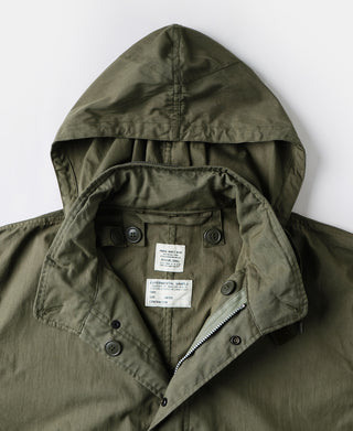 Olive M-65 parka with hood, front zipper, and inner label patch.