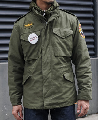 Olive field jacket with chest flap pockets and embroidered patches