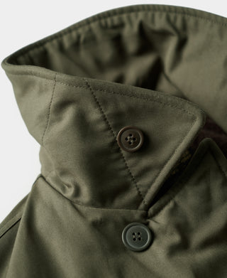 Olive flight jacket collar with two dark buttons and quilted lining.