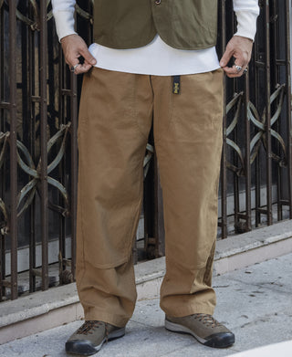Khaki cotton canvas climbing pants on model with relaxed fit and cuffed hems