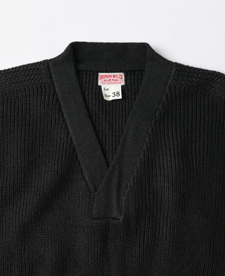 Black V-neck sweater close-up with ribbed collar and tag at neckline