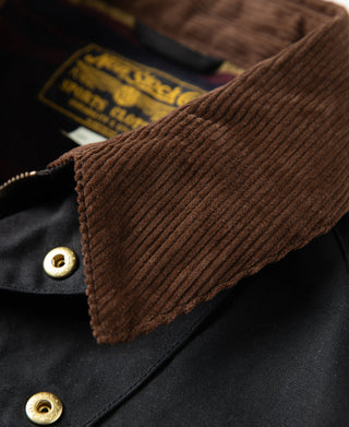 Brown corduroy cuff with brass snaps on black waxed jacket