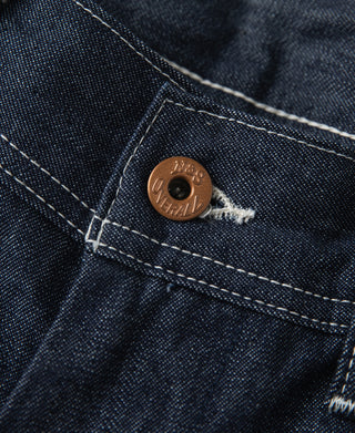 Indigo denim pants with round branded leather logo button on waistband