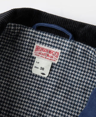 Houndstooth inner lining with size tag and black ribbed collar on blue jacket