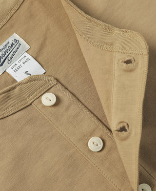 Khaki henley T-shirt close-up of three white buttons and chest placket