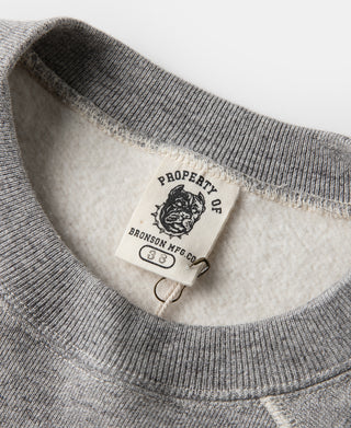 Gray crewneck sweater with inner neck tag and brand patch label.