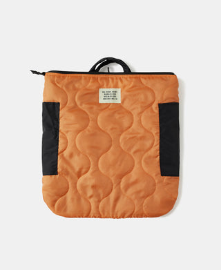 Quilted orange nylon helmet bag with black side panels, top handle, and tag