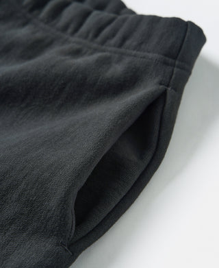 Black terry sweatpants fabric detail with stitched panels and draped fit