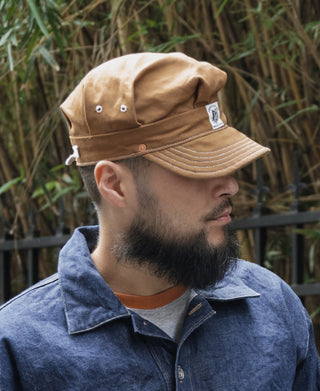 Ginger duck canvas engineer cap worn with curved brim and side eyelet vents