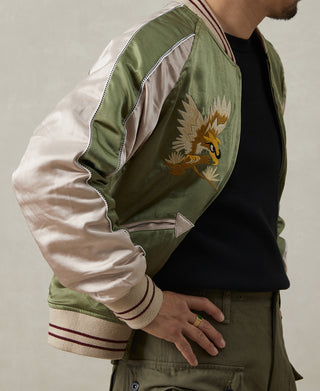 Reversible jacket side view with green body, white sleeve, and bird embroidery panel