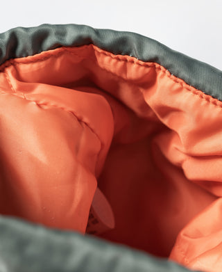 Olive chalk bag interior lining in orange with stitched seams and open top