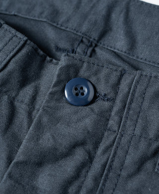 Navy shorts waistband close-up with blue button and belt-loop stitching
