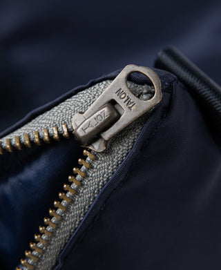 Navy helmet bag zipper with metal pull tab close-up