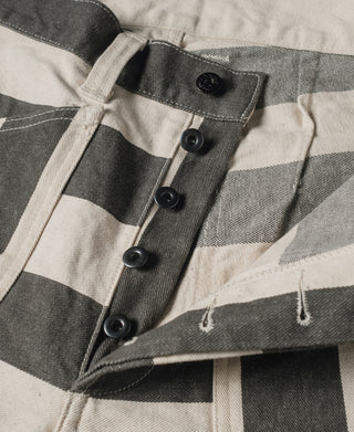Wide striped prisoner pants front, dark button placket and V-shaped pocket opening detail